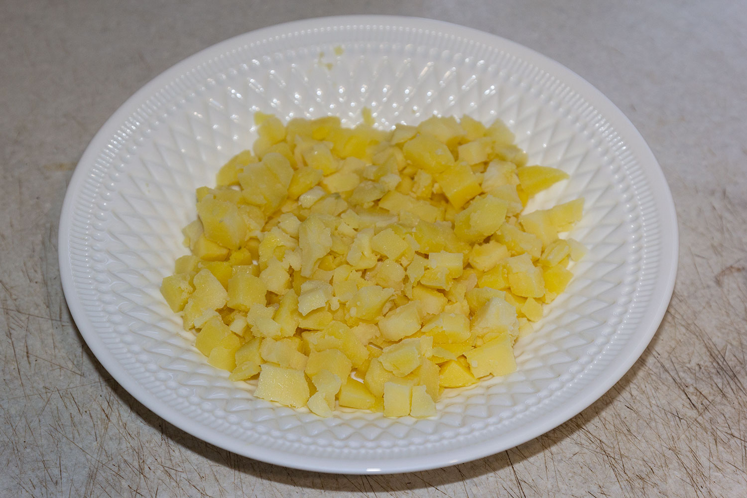 Нарезаем отварной картофель  для слоеного салата с форелью