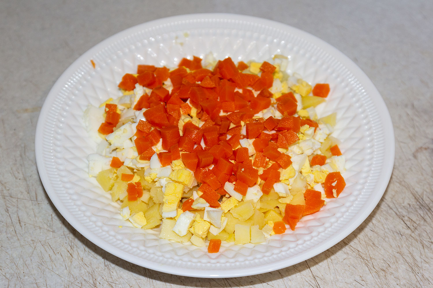 Нарезаем яйца и морковь  для слоеного салата с форелью