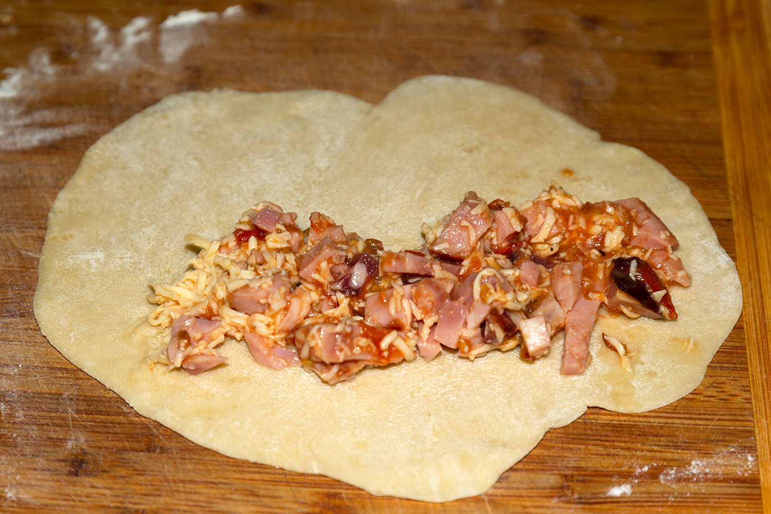 Раскатываем тесто в лепешку для рецепта Чебуреки с ветчиной, колбасой, сыром и помидорами